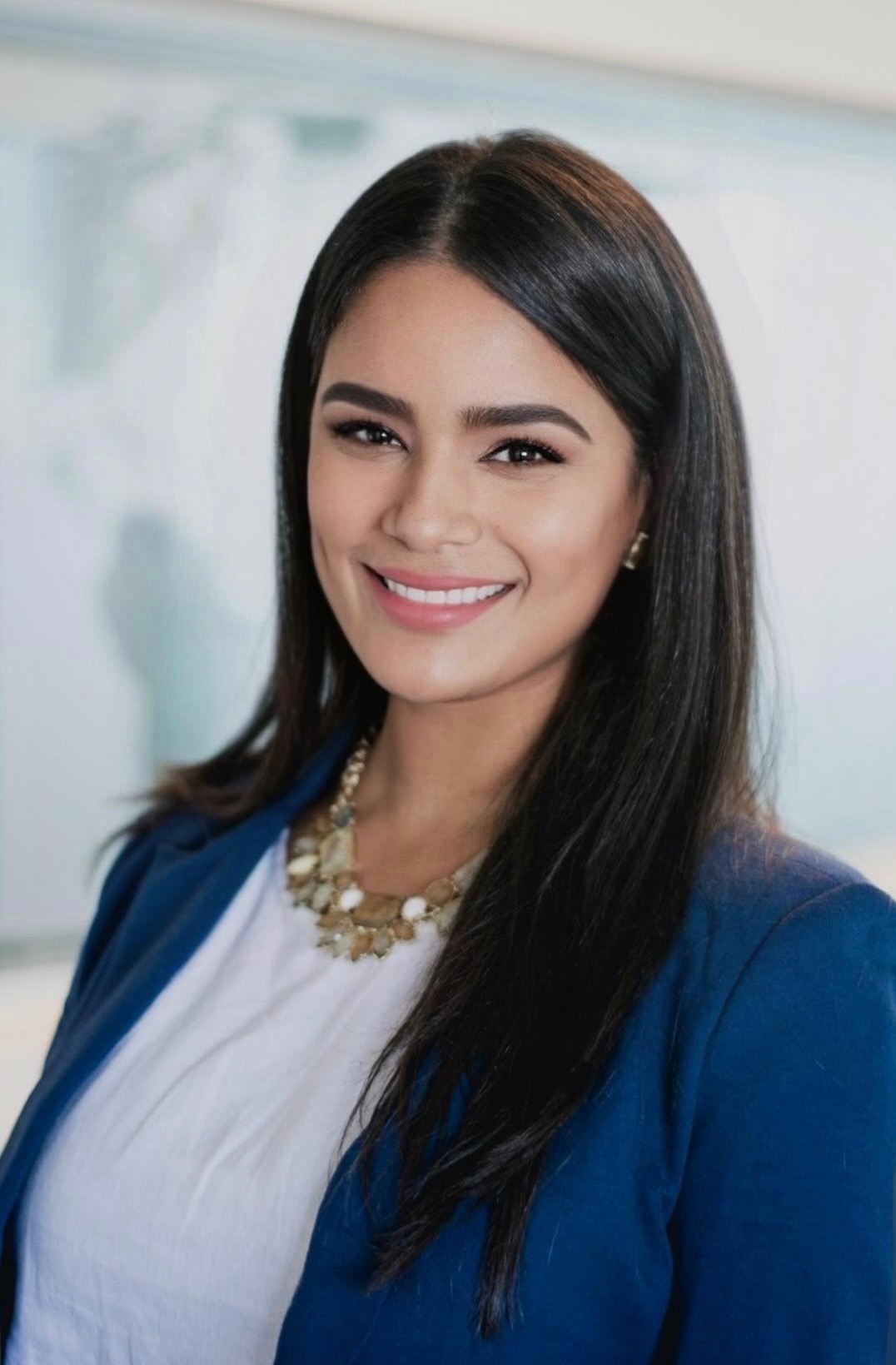Carmen Angle smiling in a blue blazer and white blouse